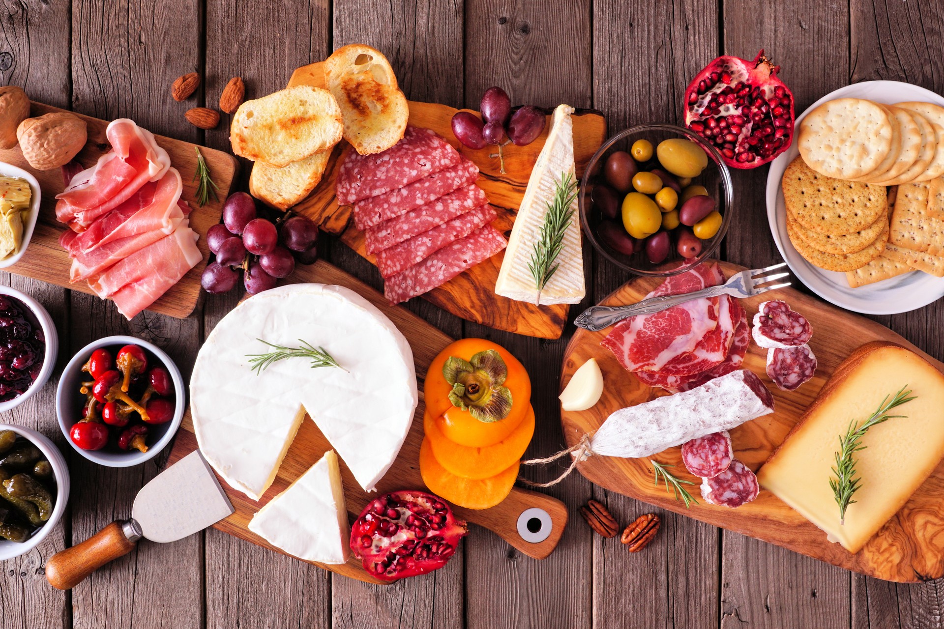 Charcuterie boards of assorted meats, cheeses and appetizers, top view table scene on rustic wood